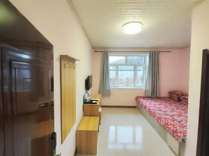 a small bedroom with a bed and a window at Snow Valley Ma Hua Inn in Wuchang
