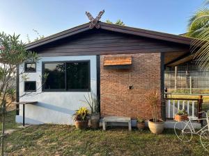 a small brick house with a door and a bench at Homestay Baan Ik-ka-lik in Nan