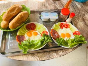 a tray with two eggs and lettuce and bread at Lộc Vừng Homestay in Phan Thiet