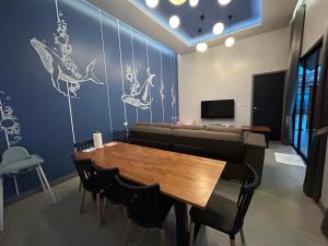 a dining room with a table and a couch at Bluda Poolvilla A in Hat Yai