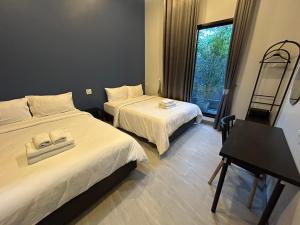 a hotel room with two beds and a window at Bluda Poolvilla A in Hat Yai +16 photos