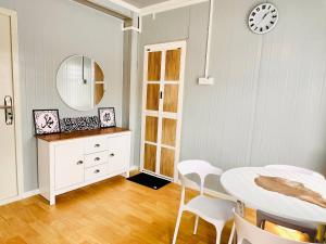 a dining room with a table and a clock on the wall at Rossaliya Cottage in Taiping