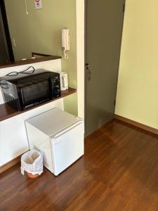 a microwave oven sitting on top of a kitchen floor at アルピエj107号室無料Wi-Fiあり熊本城徒歩5分 in Kami-kumamoto