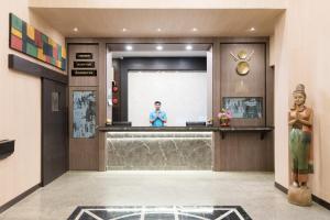 a man standing at a counter in a lobby at Bangkok Loft at Nana Station in Bangkok