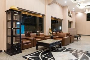 a lobby with couches and chairs and a clock at Bangkok Loft at Nana Station in Bangkok