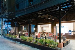 a restaurant with chairs and tables in a building at Bangkok Loft at Nana Station in Bangkok