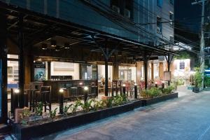 a building with a restaurant on a street at night at Bangkok Loft at Nana Station in Bangkok