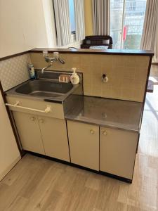 a kitchen with a sink and a counter at アルピエh 108号室WiFi使えます in Hanabatachō