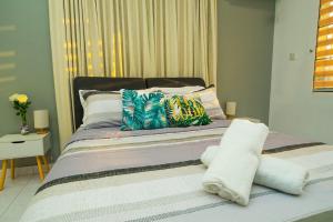 a bed with colorful pillows on it in a bedroom at Spacious 4BR Corner with Pool Table in Ipoh