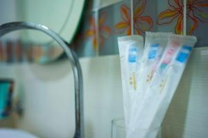 a glass of toothpaste sitting next to a sink at Spacious 4BR Corner with Pool Table in Ipoh +45 photos
