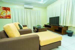 a living room with a couch and a flat screen tv at Spacious 4BR Corner with Pool Table in Ipoh