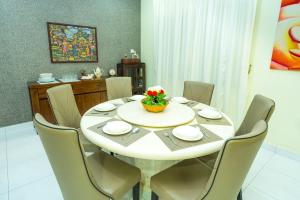 a dining room with a white table and chairs at Spacious 4BR Corner with Pool Table in Ipoh