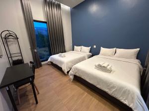 a bedroom with two beds and a desk and a window at Bluda Poolvilla B in Hat Yai +26 photos