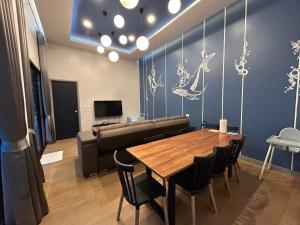 a living room with a table and a couch at Bluda Poolvilla B in Hat Yai