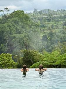 two people swimming in a body of water at Heaven in Bali in Penginyahan