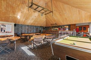 a library with tables and a pool table at Smoke Lake Hot Springs Lodge & Camp in Rotorua