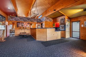 a large room with a bar in a wooden building at Smoke Lake Hot Springs Lodge & Camp in Rotorua