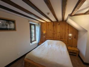 a bedroom with a bed in a room with wooden walls at Relais de la vallée de l'ource in Villars-Montroyer
