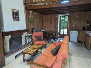 a living room with a couch and a fireplace at Relais de la vallée de l'ource in Villars-Montroyer