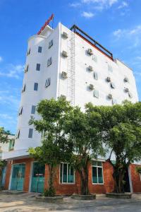 a large white building with trees in front of it at Thắng Lợi Hotel in Thanh Hóa