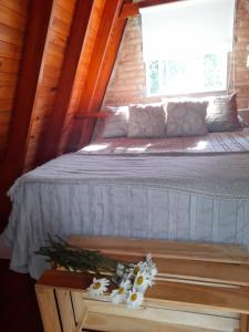 a bed in a room with a window and flowers on a table at Cabaña Balcón Serrano in Cortaderas