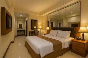 a bedroom with a large bed with a large mirror at Oak Lawang in Lawang