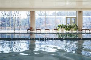 ein Schwimmbad in einem Gebäude mit Fenstern in der Unterkunft Rolling Hills Hotel in Hwaseong