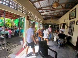 a group of people walking inside of a restaurant at Cocos Hostel in Moyogalpa