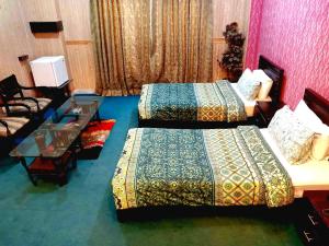 a hotel room with two beds and a couch at Divine Hotel1 in Islamabad +8 photos
