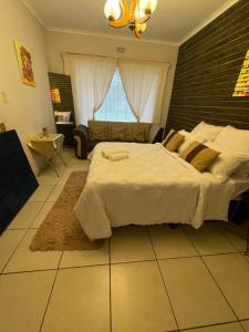 a bedroom with a large bed with a brick wall at 33 Boeren Guesthouse in Vryheid +11 photos