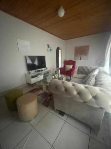 a living room with a couch and a tv at 33 Boeren Guesthouse in Vryheid