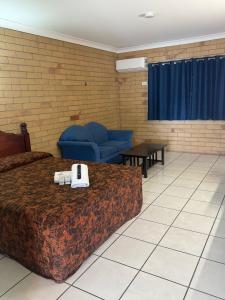 a hotel room with two beds and a couch at The Lodge Village - Workforce Accommodation in Moranbah