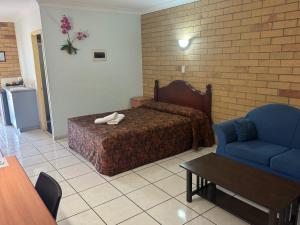 a hotel room with a bed and a blue chair at The Lodge Village - Workforce Accommodation in Moranbah