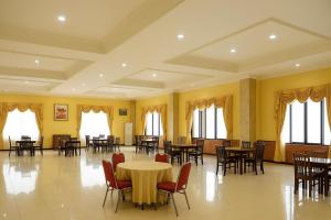 a large room with tables and chairs and windows at Oak Lawang in Lawang