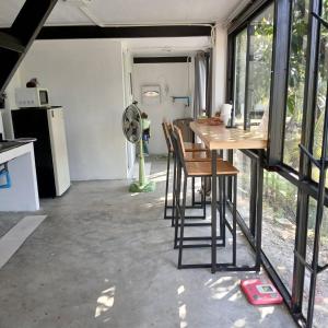 a kitchen and dining room with a table and chairs at Farmsamsook in Ban Pratu Pa Luang