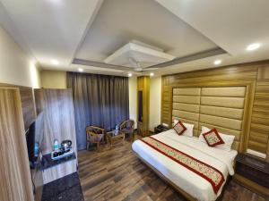 a hotel room with a large bed and a table at Pinnacle Vesta Homestay in Mussoorie