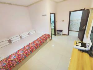 a bedroom with a bed in a room with a phone at Snow Valley Ma Hua Inn in Wuchang