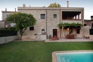 una casa de piedra con piscina frente a ella en Cal Ferrer Pujol, en Ordis