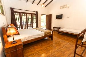 a bedroom with a bed and a bench in a room at Elephant Path by Alpine Resorts in Habarana