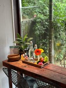 a wooden table with alcohol bottles and fruit on it at Cat Bungalow Stay in Cư Chinh