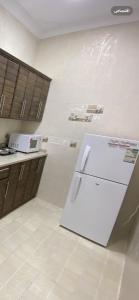 a kitchen with a white refrigerator in a room at مساكن بيتي in Yanbu