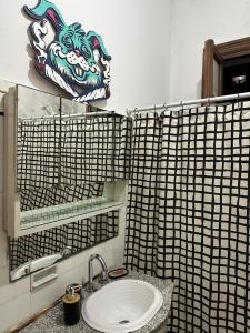 a bathroom with a sink and a mask on the wall at Av corrientes 1 in Buenos Aires