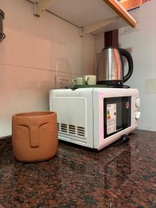 a microwave sitting on top of a kitchen counter at Av corrientes 1 in Buenos Aires