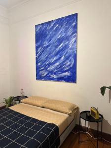 a bed in a room with a painting on the wall at Av corrientes 1 in Buenos Aires