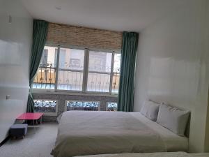 a bedroom with a bed and a large window at House of love in Xiaoliuqiu