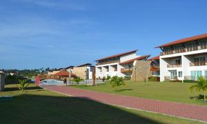 eine Reihe von Gebäuden in einem Park mit Palmen in der Unterkunft Flat Praia dos Carneiros in Praia dos Carneiros