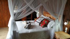 Marloth Kruger Whispering Ants في مارلوث بارك: غرفة نوم مع سرير المظلة البيضاء مع الوسائد +33 صورة