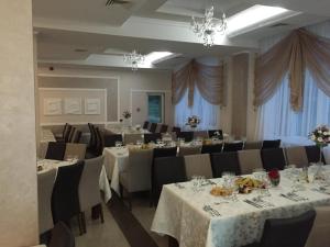 a banquet room with tables and chairs and chandeliers at Hotel-Restaurant Oscar in Piatra Neamţ