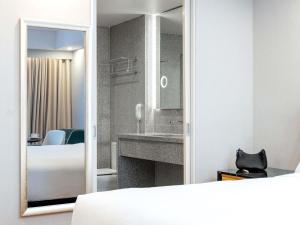 a bedroom with a bed and a sink and a mirror at Mantra Melbourne Airport in Melbourne +121 photos