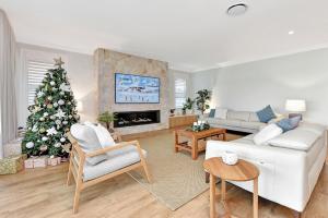 a living room with a christmas tree in it at Tilligerry Beach Retreat in Taylors Beach